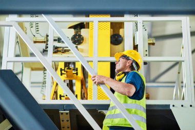 Fabrikadaki üretim hattı. Endüstriyel tesis veya kamu hizmetlerindeki ekipmanları kontrol eden veya ayarlayan teknisyen veya mühendis