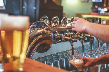 Bira musluğundaki barmen Bira dolduruyor