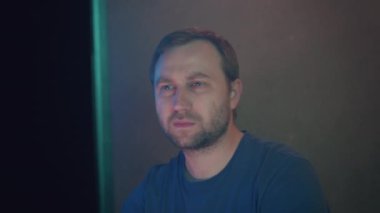Siber terörist karanlık bir ofisteki bilgisayarda çalışıyor. Mavi neon ışığı odayı aydınlatıyor..