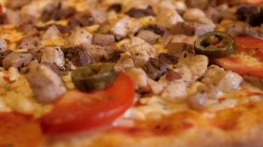 Domatesli ve biberli sıcak etli pizza daire şeklinde döner. Lezzetli İtalyan mutfağı. Restoranlar ve pizzacılar için menü ögesi.