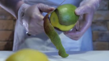 Şefin eldivenli görüntüsü mango soyuyor. Lezzetli yemekler, iştah açıcı meyveler.. 