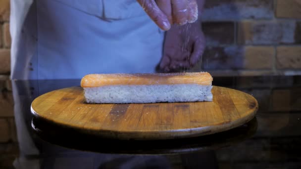 シェフは寿司巻きの上に砂糖や塩を加えます 米巻調製工程 — ストック動画