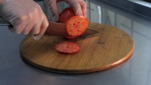 Kok Handschoenen Snijdt Een Tomaat Dunne Plakjes Houten Plaat Restaurant — Stockvideo