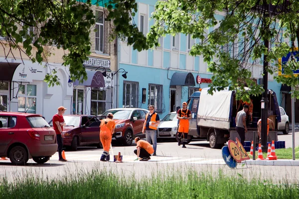 Narancssárga Egyenruhás Útépítők Egy Gyalogos Átkelést Tesznek Városban Specialisták Festéket Jogdíjmentes Stock Képek