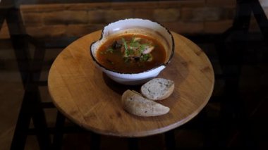 Bouillabaisse çorbası siyah tabakta ahşap tabakta döner. Restoran için menü sunumu. Deniz ürünleri çorbası sıcak baharatlı çorba, kalamar, karides, kabuk, maydanoz içerir.. 