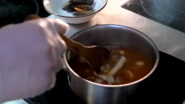 Chef está cocinando sopa Bouillabaisse con mariscos, calamares, conchas, pulpo . — Vídeo de stock
