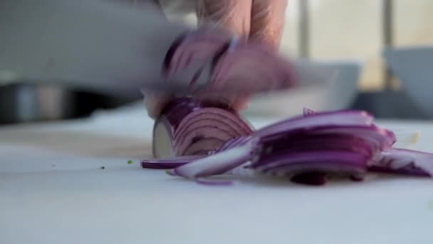 Chef in guanti taglia cipolla viola sul tagliere bianco. — Video Stock