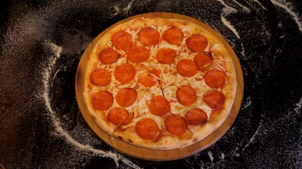 Ruce berou plátky pepperoni pizzy pryč od dřevěné desky. — Stock video