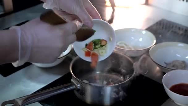 Шеф-повар готовит аппетитный суп из овощей, креветок, кальмаров, суаче. Морской суп — стоковое видео