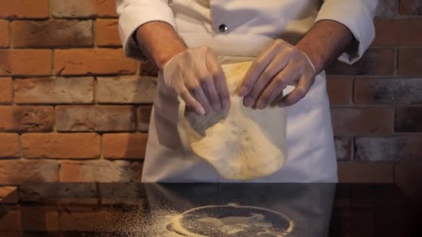 Šéf připravuje syrové těsto na pizzu. Ruce nahnědnout těsto detailní záběr. — Stock video