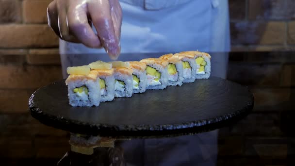 Chef está decorando rollos de arroz, sushi maki con rodajas de limón . — Vídeos de Stock