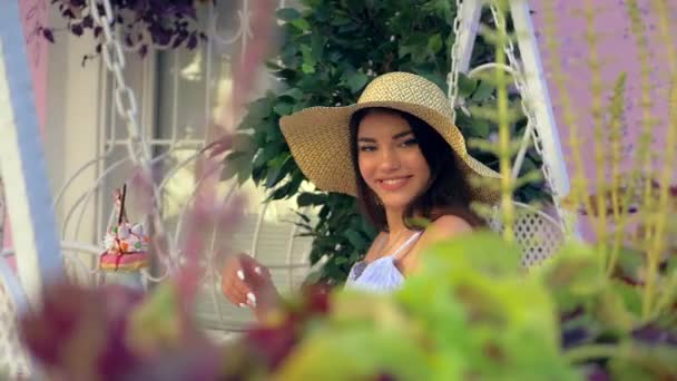 Charmante en elegante Spaanse vrouw met brede hoed buiten in cafe — Stockvideo