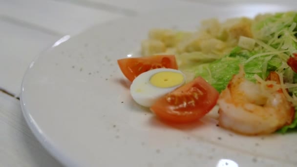 Närbild av Caesar sallad med räkor, krutonger, körsbärstomater och vaktelägg. Smaklig och läcker. — Stockvideo