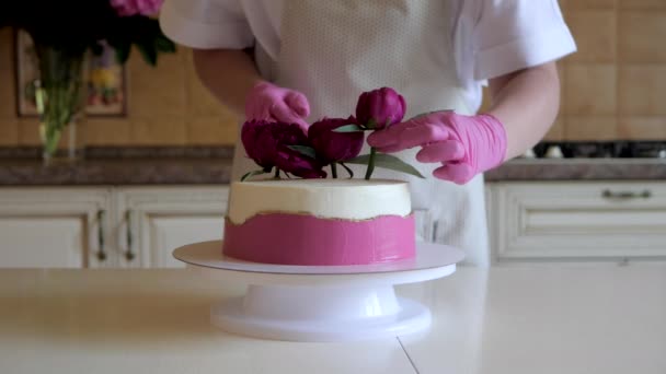 Bakverk kock dekorerar festlig tårta med färska blommor av röda pioner — Stockvideo