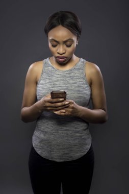 Egzersiz veri, endişeli veya metin mesajları okuyarak egzersiz dan dikkatin arıyorsunuz bir akıllı telefon fitness app kullanarak siyah kadın atlet