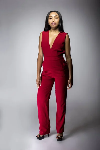 Black African American female model wearing a stylish red casual apparel.  The fashionable outfit looks modern and trendy.  The image depicts shopping and fashion industry.