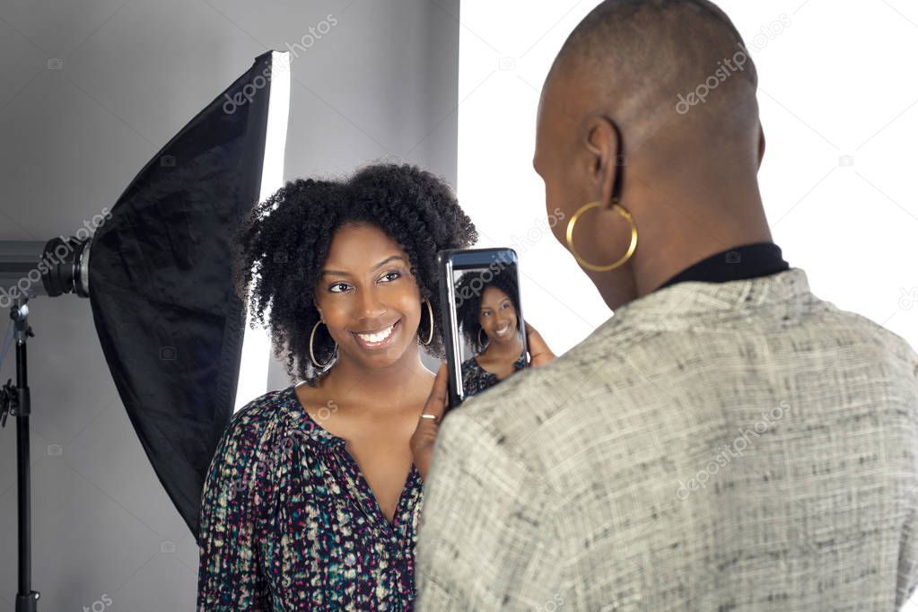 Black female actress doing a self tape audition via cell phone camera in a studio while reading to a casting director.  Depicts the Hollywood entertainment industry process.