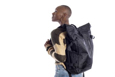 Siyah Afrikalı-Amerikalı kadın ve kompozitler için beyaz arka plan bakarak bir sırt çantası giyiyor. O bir turist veya bir uzun yürüyüşe çıkan kimse trekking gibi standiing o. 