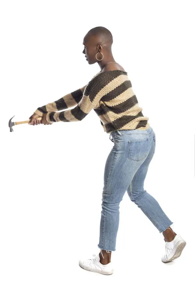 黑人非洲裔美国女性挥动锤子假装击中或粉碎白色背景 她正在毁坏或修理什么东西 Diy 家的改善或女权主义的自力更生 — 图库照片
