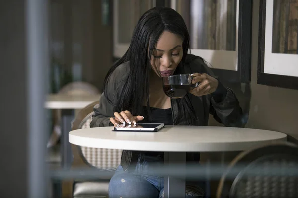 Wifi に接続されたタブレットを使用して黒人女性のウィンドウ表示にあるコーヒー ショップでインターネット 実業家や学生は休憩や仕事やカフェで勉強 — ストック写真