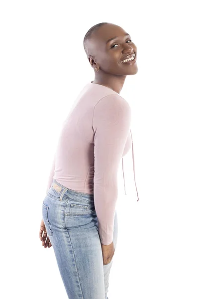 黑人非洲裔美国女模特与秃头发型穿着粉红色的衬衫在白色背景看起来害羞和尴尬 — 图库照片