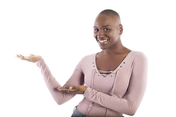 白い背景の広告にピンクのシャツを着て または何かを提示するハゲの髪型を持つ黒人アフリカ系アメリカ人の女性モデル — ストック写真