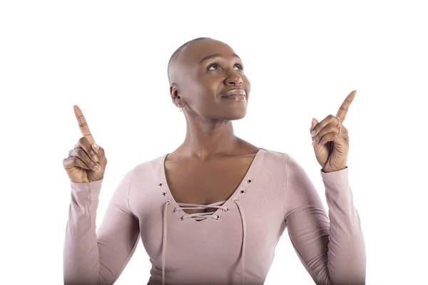 白い背景の広告にピンクのシャツを着て または何かを提示するハゲの髪型を持つ黒人アフリカ系アメリカ人の女性モデル — ストック写真