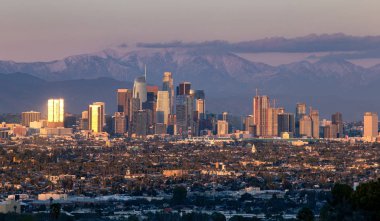 Los Angeles California şehrinin panoramik manzarası, iklim değişikliği nedeniyle kuraklığın sona erdiğini gösteren karlı dağ kapakları ile. Geniş görünümü Hollywood ve Downtown gösterir.