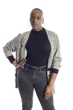 Siyah Afro-Amerikan kadın beyaz bir arka plan üzerinde modern iş rahat kıyafet giyerken kendinden emin görünümlü. İş kadını cesur kentsel moda stilini betimliyor. 