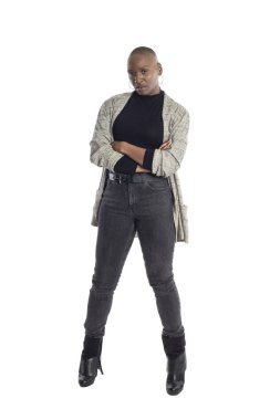 Siyah Afro-Amerikan kadın beyaz bir arka plan üzerinde modern iş rahat kıyafet giyerken kendinden emin görünümlü. İş kadını cesur kentsel moda stilini betimliyor. 