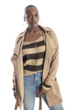 Kendine güvenen siyah Afrikalı-Amerikalı kadın model bir ceket veya ceket ve kot pantolon ile Sonbahar veya Bahar tarzı moda giyiyor. O kel bir saç modeli ve beyaz bir arka plan üzerinde izole.  