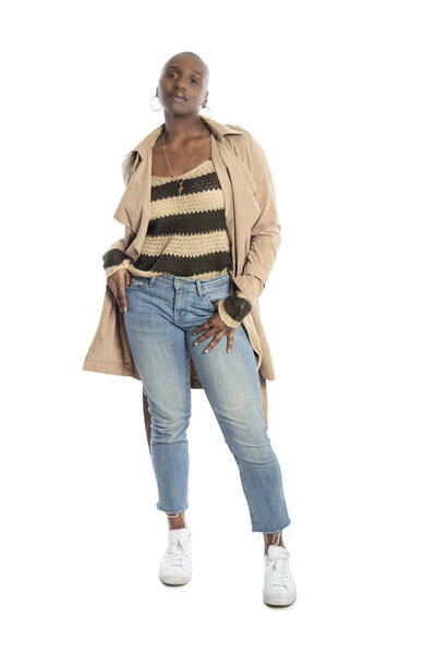 Уверенная чернокожая афроамериканская модель в стиле осени или весны с курткой или джинсами. У неё лысая прическа и изолированная на белом фоне.
.  
