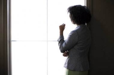 Ofis penceresinde düşünen siyah bir Afro-Amerikan iş kadını silueti. O beyin fırtınası veya onu başlangıç iş için planlama. 