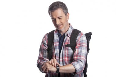 Orta yaşlı bir adam veya yaşlı vatandaş bir akıllı saat üzerinde sağlık uygulamaları ile kalp hızı nabız kontrol. O da gps navigasyon için giyilebilir teknolojiyi kontrol eden bir yürüyüşçü gibi görünüyor.