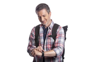 Orta yaşlı bir adam veya yaşlı vatandaş bir akıllı saat üzerinde sağlık uygulamaları ile kalp hızı nabız kontrol. O da gps navigasyon için giyilebilir teknolojiyi kontrol eden bir yürüyüşçü gibi görünüyor.