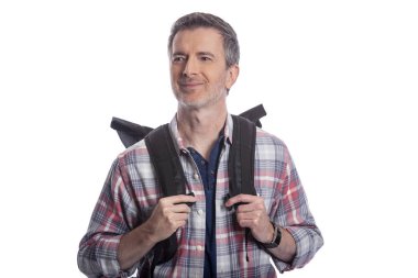 Orta Yaşlı adam yürüyüş veya trekking ya da seyahat ederken bir turist olarak yürüyüş tarafından emeklilik sırasında sağlıklı aktiviteler yapıyor. O beyaz bir arka plan üzerinde bir sırt çantası taşıyan kendinden emin ve mutlu görünüyor.