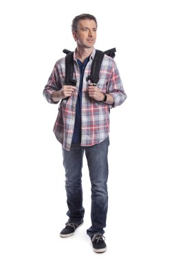 Orta Yaşlı adam yürüyüş veya trekking ya da seyahat ederken bir turist olarak yürüyüş tarafından emeklilik sırasında sağlıklı aktiviteler yapıyor. O beyaz bir arka plan üzerinde bir sırt çantası taşıyan kendinden emin ve mutlu görünüyor.