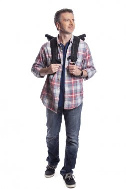 Orta Yaşlı adam yürüyüş veya trekking ya da seyahat ederken bir turist olarak yürüyüş tarafından emeklilik sırasında sağlıklı aktiviteler yapıyor. O beyaz bir arka plan üzerinde bir sırt çantası taşıyan kendinden emin ve mutlu görünüyor.