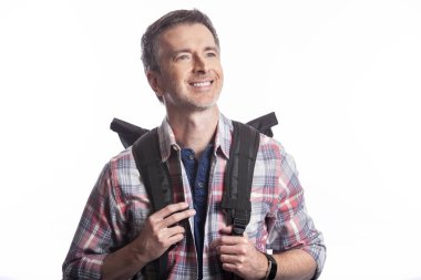 Orta Yaşlı adam yürüyüş veya trekking ya da seyahat ederken bir turist olarak yürüyüş tarafından emeklilik sırasında sağlıklı aktiviteler yapıyor. O beyaz bir arka plan üzerinde bir sırt çantası taşıyan kendinden emin ve mutlu görünüyor.