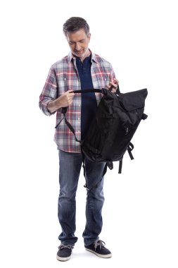 Orta yaşlı adam yürüyüş veya trekking için bir sırt çantası hazırlanıyor. O da bir turist paketleme el bir yolculuk için hazırlık bagaj taşımak olabilir.