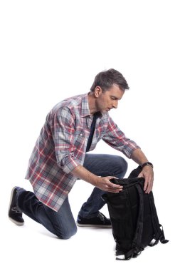 Orta yaşlı adam yürüyüş veya trekking için bir sırt çantası hazırlanıyor. O da bir turist paketleme el bir yolculuk için hazırlık bagaj taşımak olabilir.