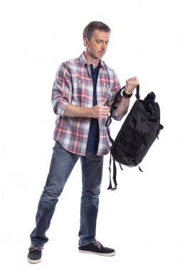 Orta yaşlı adam yürüyüş veya trekking için bir sırt çantası hazırlanıyor. O da bir turist paketleme el bir yolculuk için hazırlık bagaj taşımak olabilir.