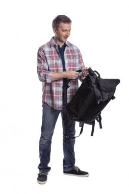 Orta yaşlı adam yürüyüş veya trekking için bir sırt çantası hazırlanıyor. O da bir turist paketleme el bir yolculuk için hazırlık bagaj taşımak olabilir.