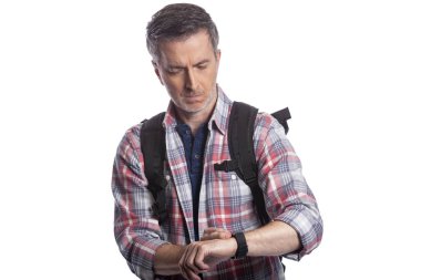 Orta yaşlı bir adam veya yaşlı vatandaş bir akıllı saat üzerinde sağlık uygulamaları ile kalp hızı nabız kontrol. O da gps navigasyon için giyilebilir teknolojiyi kontrol eden bir yürüyüşçü gibi görünüyor.