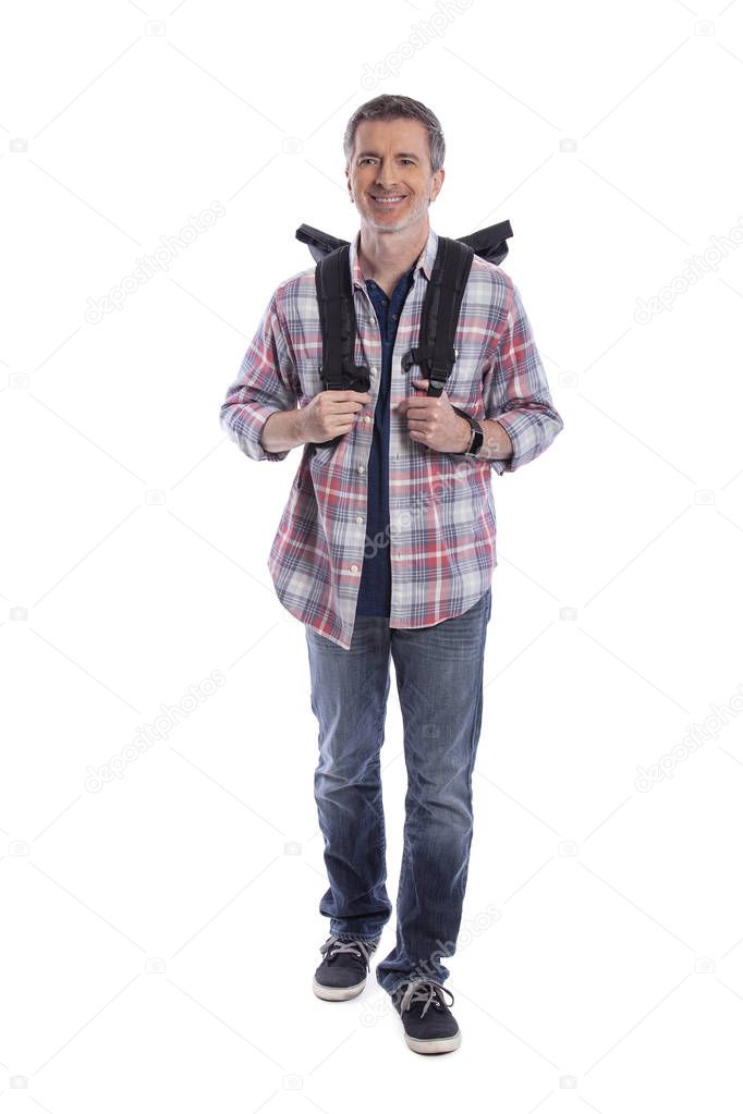 Middle-Aged man doing healthy activities during retirement by hiking or trekking or walking as a tourist when traveling.  He looks confident and happy carrying a backpack on a white background.