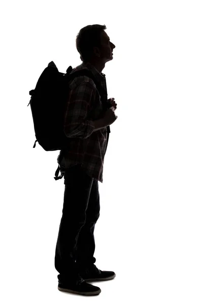 男性ツアーガイドのシルエットハイキングと白い背景にバックパックを運ぶ 隔離された側面図の男は合成物のために使用することができる 冒険と探検を描く — ストック写真