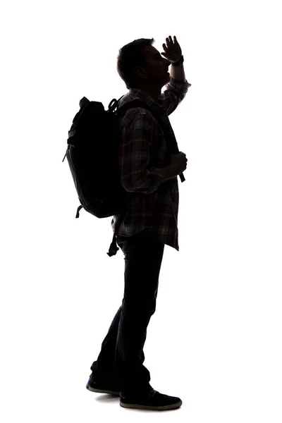 男性ツアーガイドのシルエットハイキングと白い背景にバックパックを運ぶ 隔離された側面図の男は合成物のために使用することができる 冒険と探検を描く — ストック写真