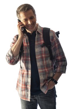 Yürüyüşçü yol tarifi veya yardım istemek için bir telefon görüşmesi yapmak için bir cep telefonu kullanarak. Beyaz arka plan üzerinde izole edilmiş ve kompozitler için gün batımı ışığı ile aydınlatılmış. 