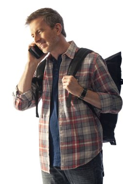 Yürüyüşçü yol tarifi veya yardım istemek için bir telefon görüşmesi yapmak için bir cep telefonu kullanarak. Beyaz arka plan üzerinde izole edilmiş ve kompozitler için gün batımı ışığı ile aydınlatılmış. 