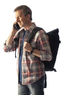 Yürüyüşçü yol tarifi veya yardım istemek için bir telefon görüşmesi yapmak için bir cep telefonu kullanarak. Beyaz arka plan üzerinde izole edilmiş ve kompozitler için gün batımı ışığı ile aydınlatılmış. 